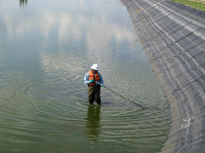 worker checking for geomembrane leaks
