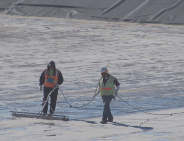 workers testing for geomembrane leaks