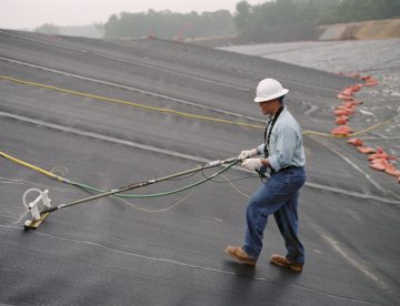 worker checking for a landfill liner failure
